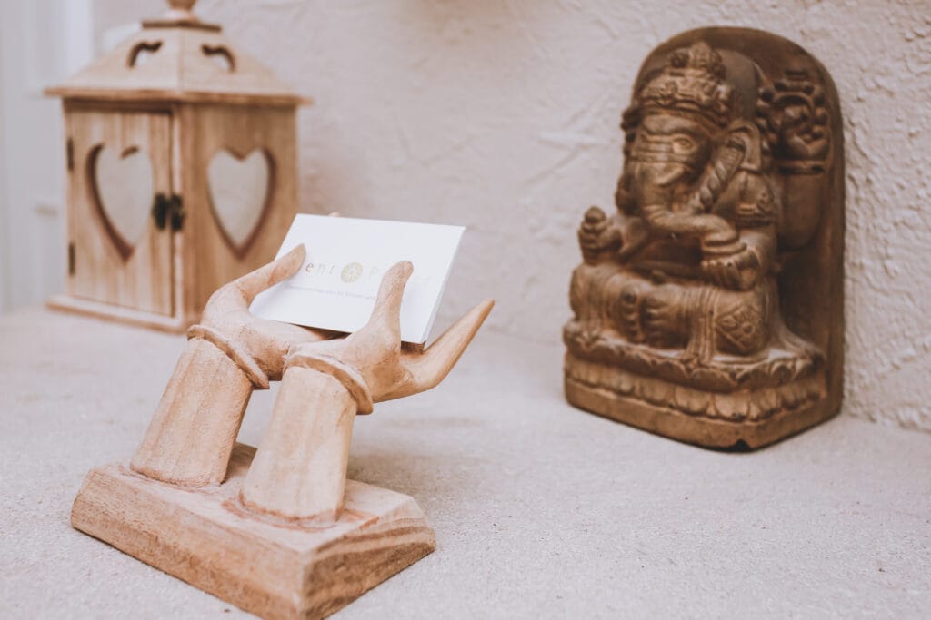 Holzhände mit Herz-Laterne und Ganesha-Figur in ruhiger Atmosphäre